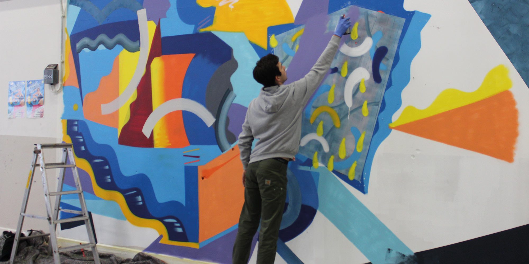 A male graffiti artist painting on a wall during our Breaking Convention season at Mayflower Theatre.