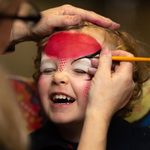 A young child having their face painted at our Family Fun Day.