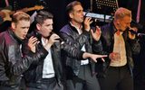 Four men in leather jackers singing