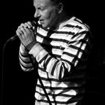 Steve Ellis black and white photo wearing stripy jumper singing with feeling
