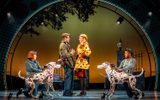 Two life-sized puppet dalmatians wrap Roger and Anita together in their leads in the park