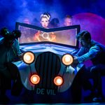Kym Marsh as Cruella de Vil driving a car at night, held together by ensemble