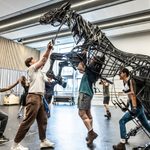 The cast of War Horse operating a rearing life-sized puppet horse in a rehearsal studio