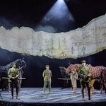 Stewart (Daniel Rock), Billy (Haydn Burke) and Nicholls (Chris Williams) stand in uniform in front of horse Topthorn (puppeteers Rianna Ash, Chris Milford, Thomas Goodridge) and horse Joey (puppeteers Matthew Lawrence, Rafe Young, Felicity Donnelly)