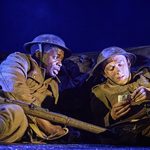 David Taylor (Ike Bennett) and Albert Narracott (Tom Sturgess) laying in the trenches, Albert reading a letter