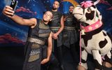 Family Trot (Perri Kiely, Ashley Banjo and Jordan Banjo) take a selfie on a mobile with the pantomime cow