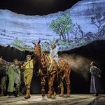 Emillie (Diany Samba-Bandza) rides horse Joey (puppeteers Matthew Lawrence, Rafe Young, Felicity Donnelly) as Friedrich (Alexander Ballinger) watches from next to horse Tophorn (puppeteers Rianna Ash, Chris Milford, Thomas Goodridge)