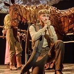 Albert Narracott (Tom Sturgess) kneels with clasped hands to his lips, horse Joey (puppeteers Matthew Lawrence, Rafe Young, Felicity Donnelly) behind him