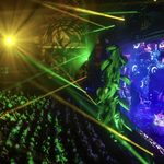 Side view of Mayflower Theatre auditorium, the audience looking up at a giant beanstalk growing out of the front of the stage where Dame Trot (Matt Rixon) and a fairy watch on