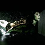 Large projection across stage of Asian woman diving through water