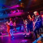 Side view of guitarist, tambourine player and backing singers