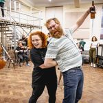 Carrie Hope Fletcher (Calamity Jane) arm locks a man with a beard who is holding a beer in the air