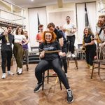 Carrie Hope Fletcher (Calamity Jane) being tied up on a chair by Vinny Cole (Wild Bill Hickok) as musicians happily watch in a circle around