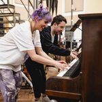 Hollie Cassar (Susan) and Isaac Savage (Francis Fryer) standing over a piano, grinning as they play together