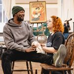 Luke Wilson (Danny Gilmartin) propping his leg up on a chair and Carrie Hope Fletcher (Calamity Jane) kneeling next to him in concern