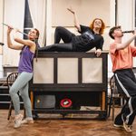 Carrie Hope Fletcher (Calamity Jane) reclines on top of a piano as Emma Jane Morton (Swing) plays flute to her right, Fergus Murphy (Joe & Harry) plays clarinet to her left, and Theo Diedrick (Swing) plays violin in the back