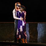 Grace wearing purple robe unties Thomas Shelby' blindfold as he holds her in his arms