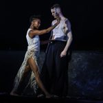 Grace, wearing lacy wedding dress, pushes against Tommy, holding a gun against his face