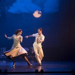 Victoria Page (Ashley Shaw, wearing spotted jacket and knee- length skirt) and Boris Lermontov (Sam Archer, wearing beige slacks, braced over white shirt and beige tie) dance at night