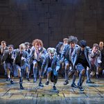 A class of school kids stomp menacingly towards the camera