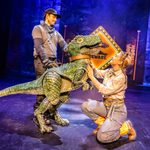 Female ranger pats baby t-rex puppet with leather collar