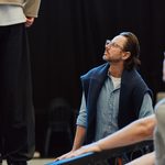 Man in glasses, sitting, looking up at action happening to the side