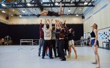 Quadrophenia dancers throw a blond man in the air, arms raised to catch him as blonde woman watches on