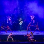 202503PeakyBlinders@BeatriceLivet-40 Petals fall around a spotlighted Tommy, facing away from the camera, as pairs of dancers surround him