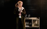 Woman looing left holding bottle.
