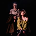 Woman sat on chair with another woman stood behind her